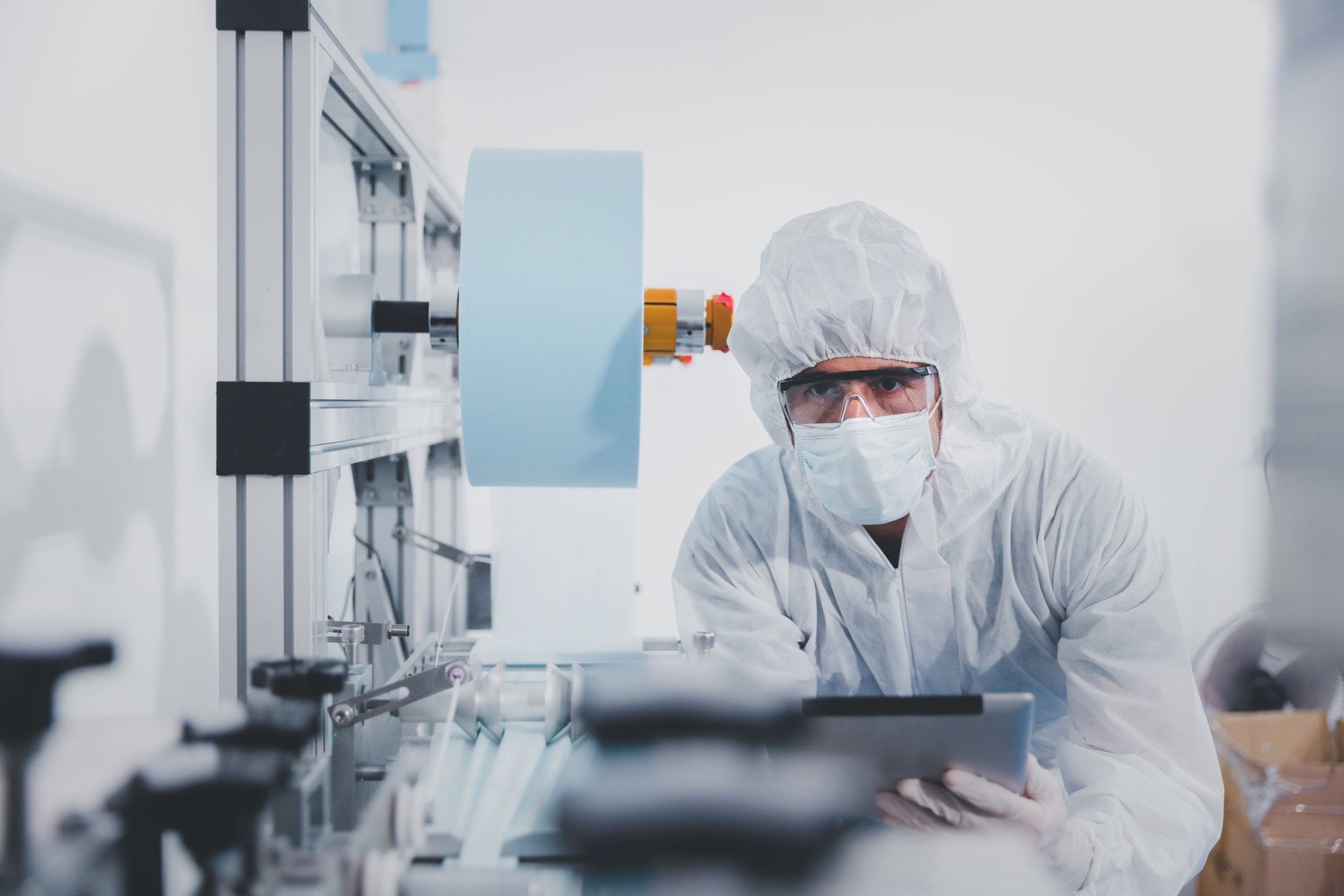 Engineer or technician using digital tablet control and check medical mask production